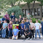 A group of students pose by the Energy Institute Truck in front of the Rawhide Power Station
