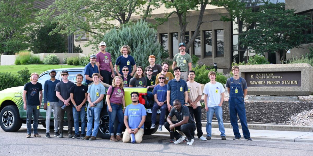 A group of students pose by the Energy Institute Truck in front of the Rawhide Power Station