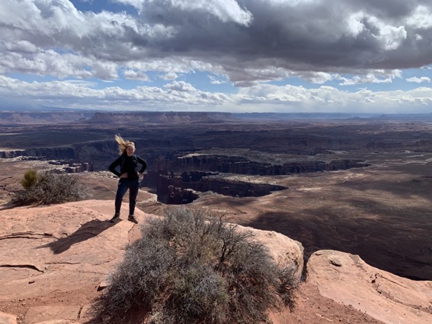 Emily Luetschwager stands in front of a series of canyons