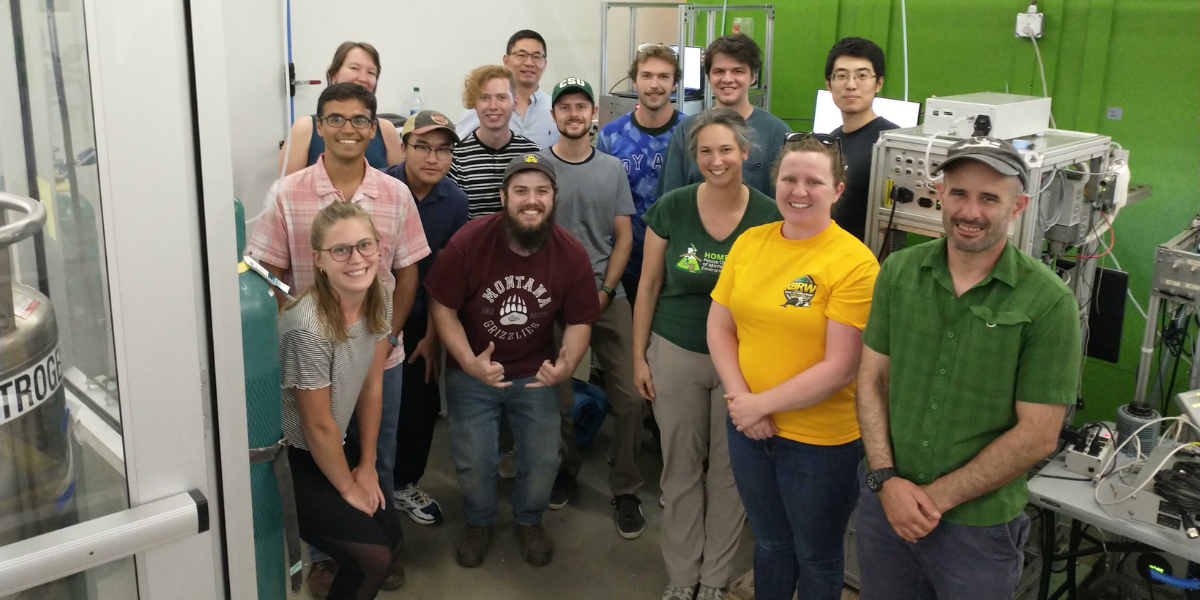 A group of 14 people stands in a lab at the Powerhouse