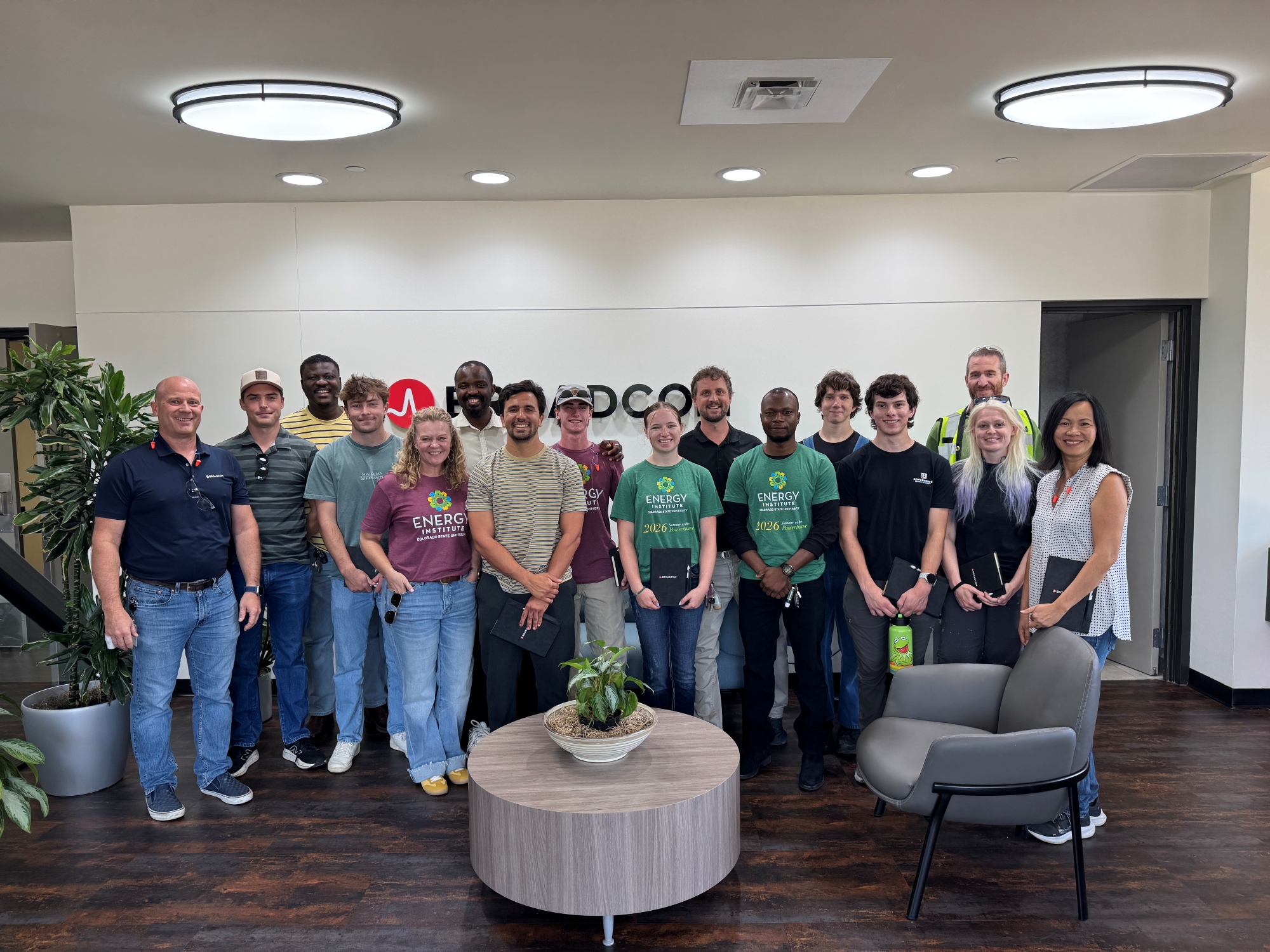 A group from the Powerhouse stands and poses for a photo in the lobby of Broadcom