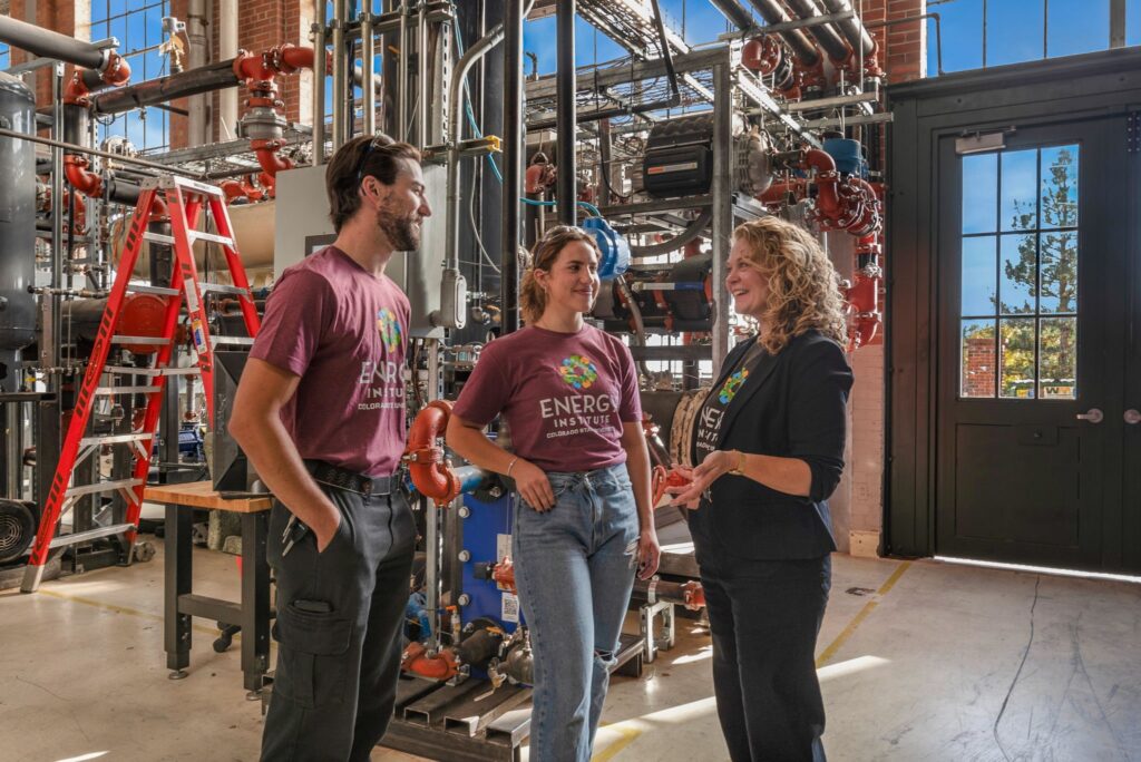 Two students and a staff member talk in a lab at the Powerhouse.