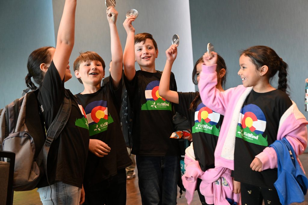 5 students hold their medals at KidWind and cheer