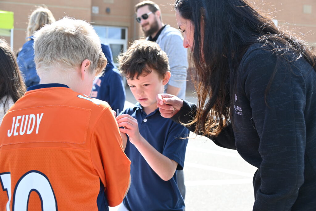 A volunteer helps two children complete an activity. 