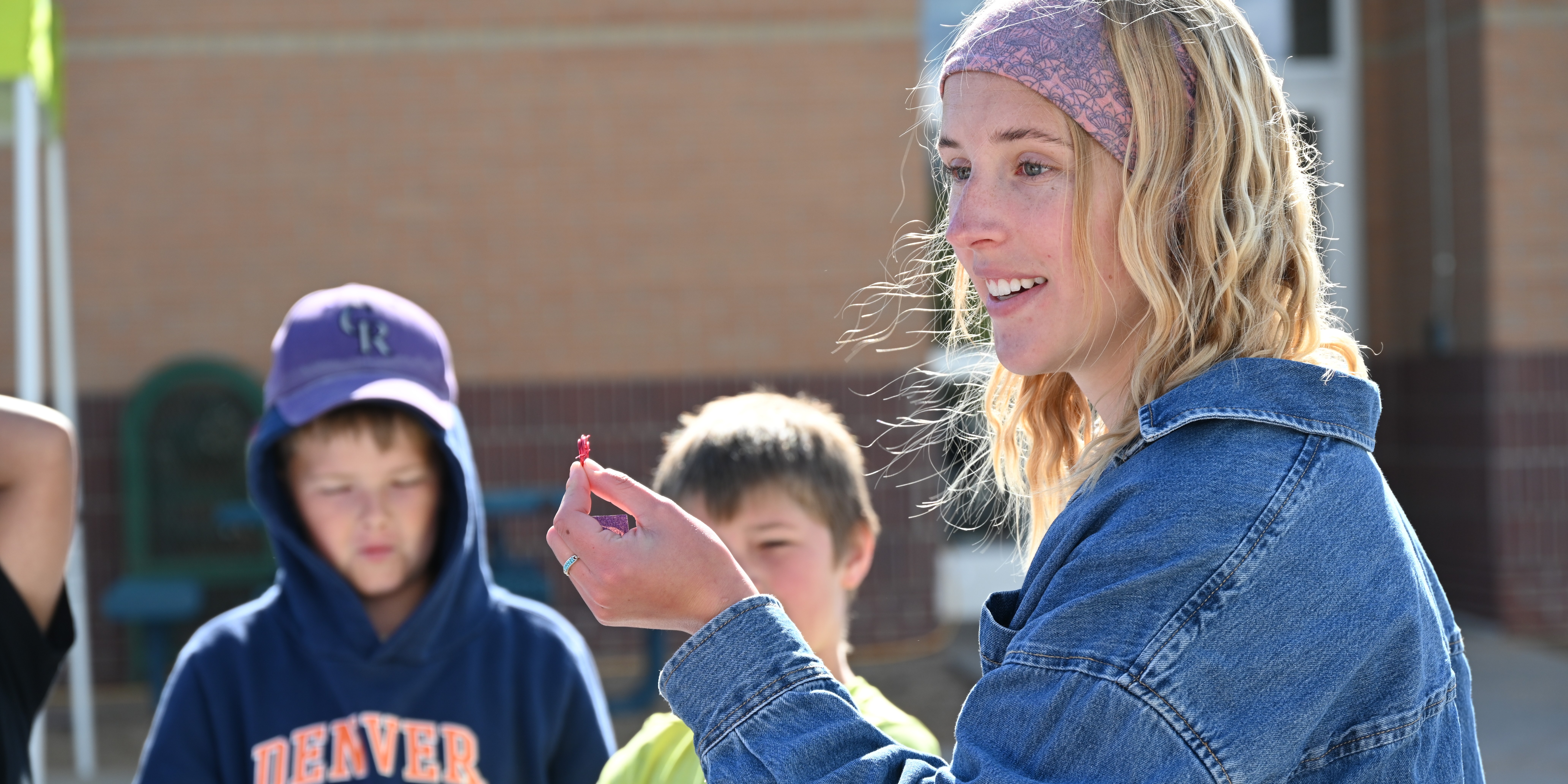 A student ambassador shows elementary school students how to complete an activity.