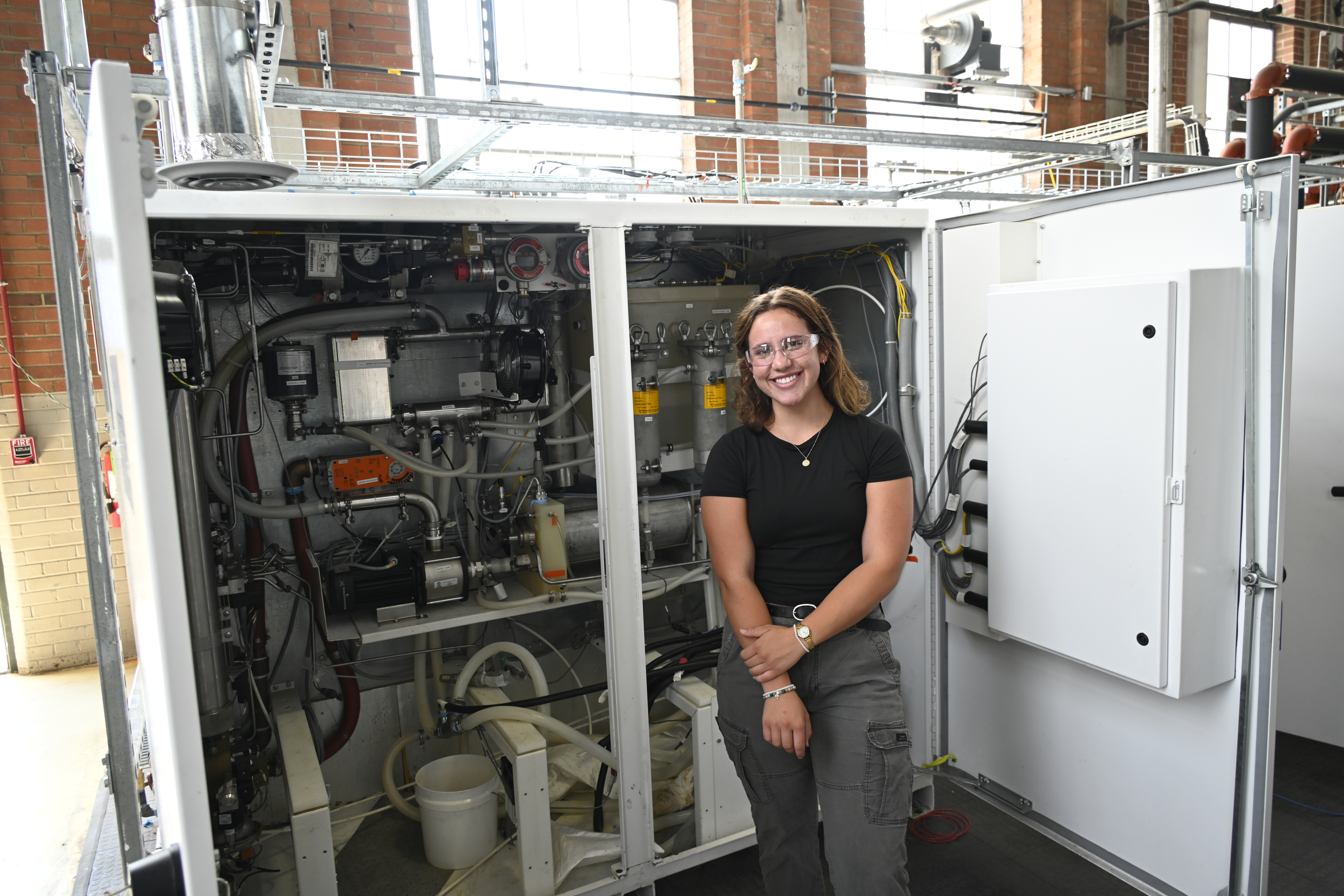 Samantha Pruess stands in front of equipment in the Engines and Energy Conversion Lab