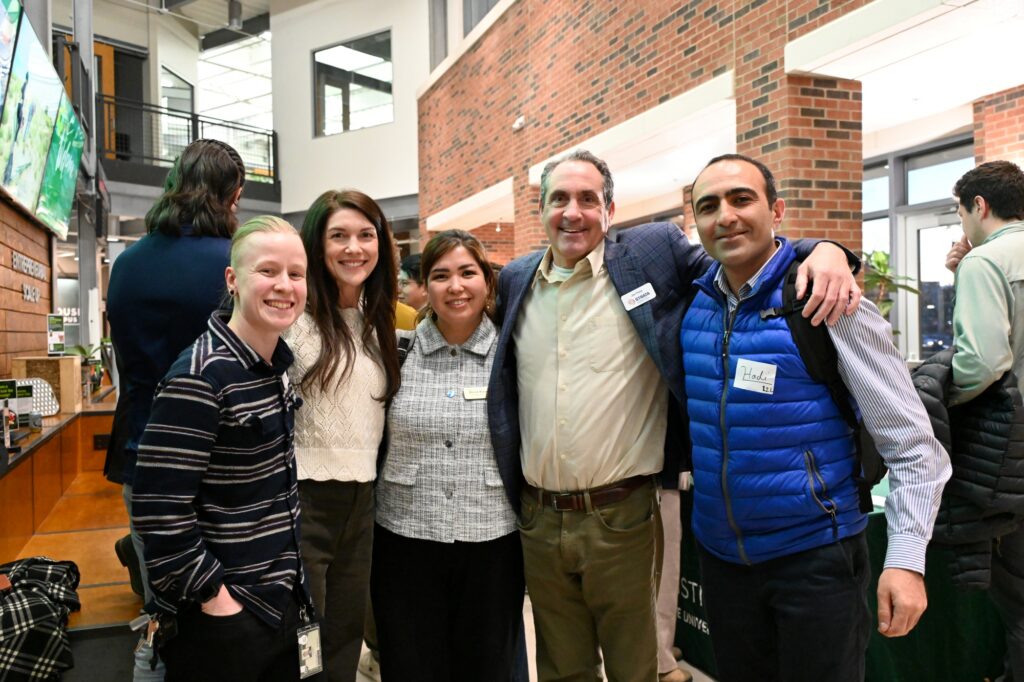 A group poses for the camera in the Powerhouse lobby at an event.