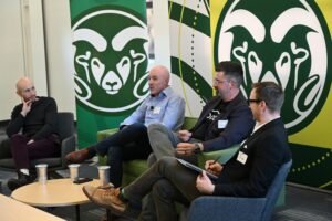 A group of four people sit on a panel at the event