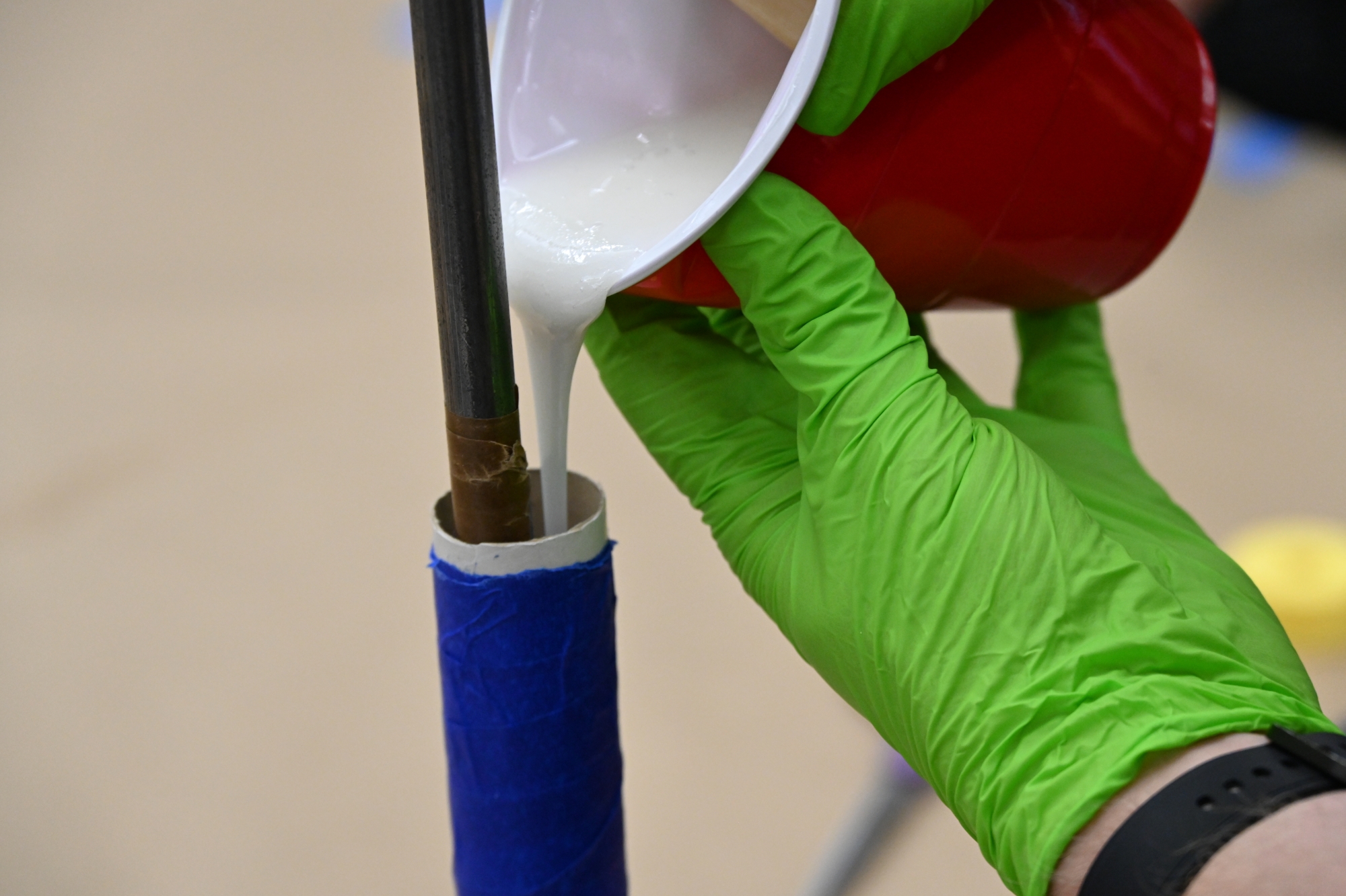 A student pouring a fuel mixture into a mold
