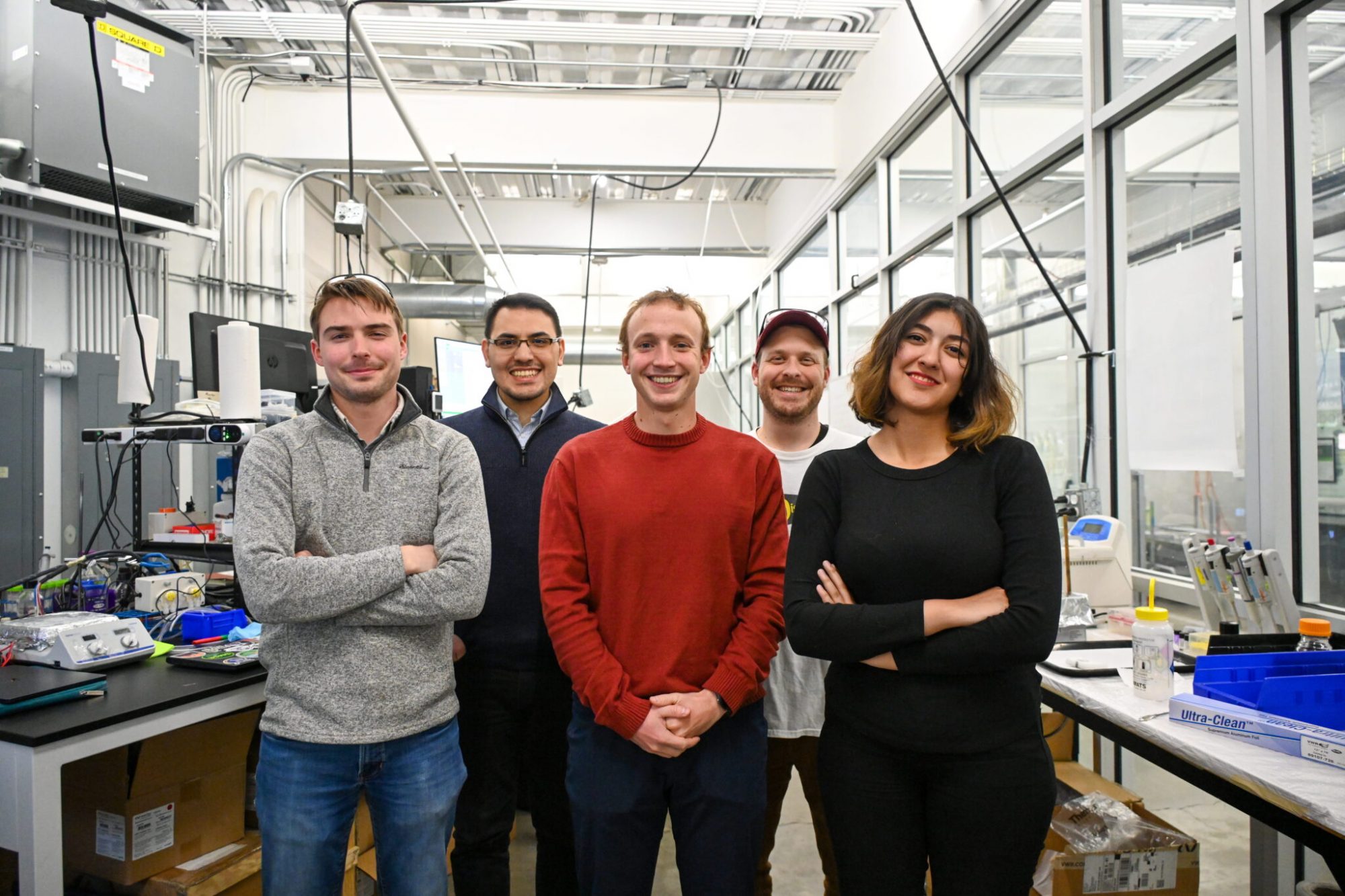 5 researchers stand in the RECS lab and smile